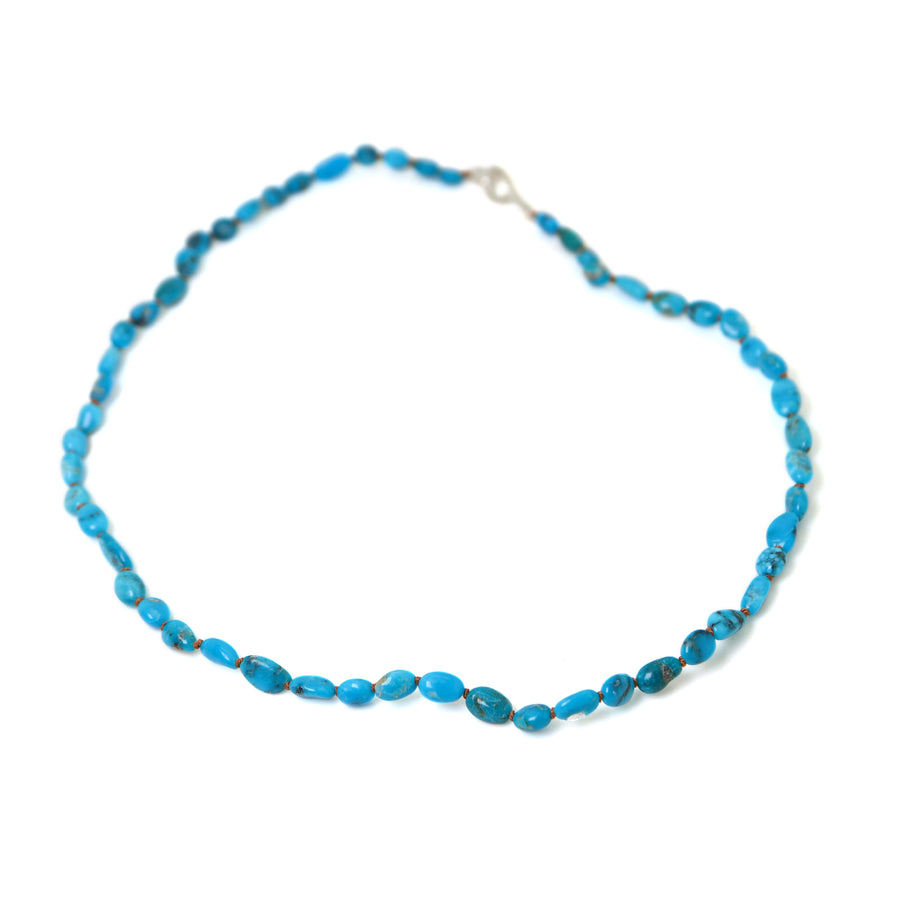 varying hades of tropical blue turquoise are strong on burnt sienna silk with silver clasp