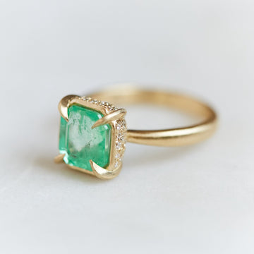 A 2.35ct Emerald ring with an 18k gold setting and band. Four gold prongs secure the Emerald to the setting. The setting is inlaid with .32ct diamonds.