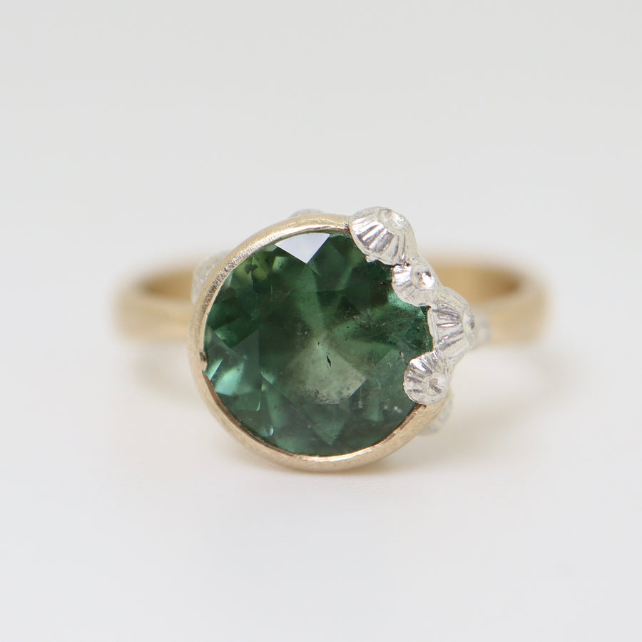 A 2.74ct tourmaline ring. The tourmaline is a deep green and is set in 14k gold with a 14k gold band. The rsetting is encrusted with bright sterling silver barnacles.