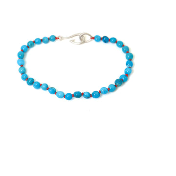 vibrant kingman turquoise beads are knotted on red silk with silver fish hook clasp in this bracelet