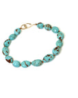 mottled kingman turquoise beads are strung on brown silk with 14k yellow gold fish hook clasp