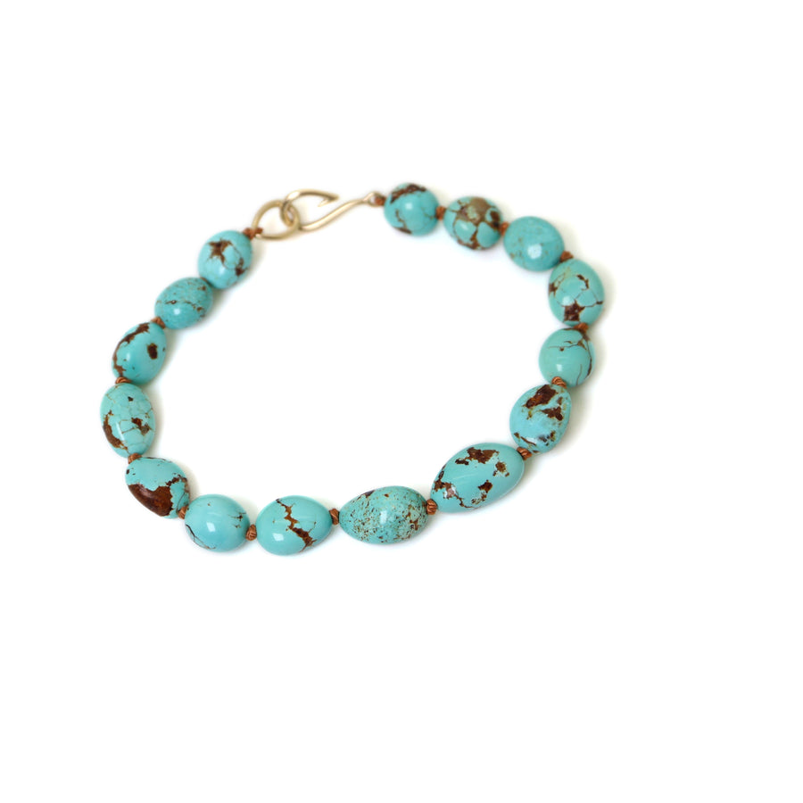 mottled kingman turquoise beads are strung on brown silk with 14k yellow gold fish hook clasp