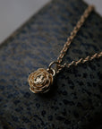 gold rose pendant necklace on leather jewelry box