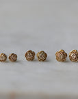 three pairs of gold rose garden studs in varying sizes.