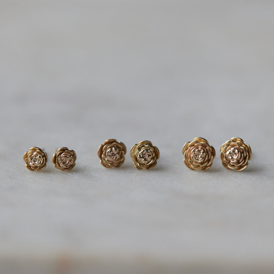 three pairs of gold rose garden studs in varying sizes.