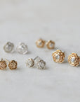 five pairs of rose garden studs in varying metals. Some have diamonds and some do not.