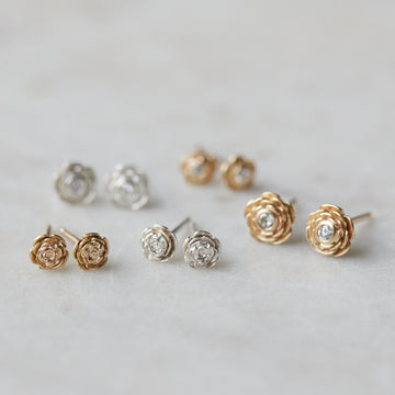 five pairs of rose garden studs in varying metals. Some have diamonds and some do not.