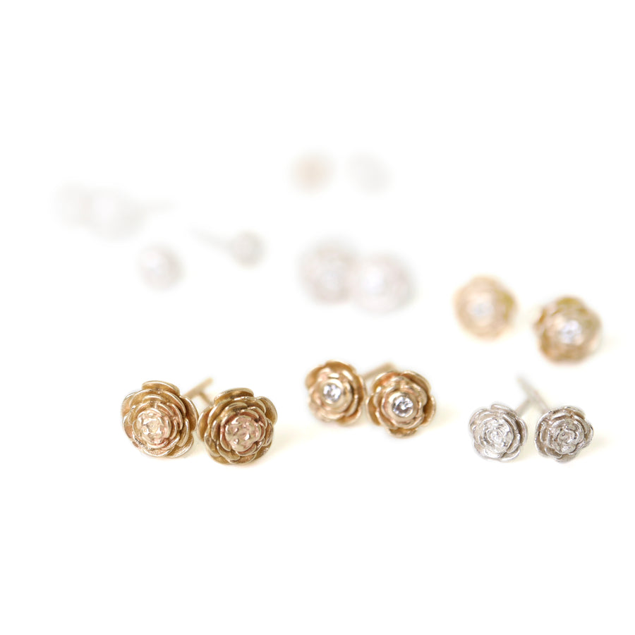 varying sizes and metals of rose earring studs. Some have diamonds.