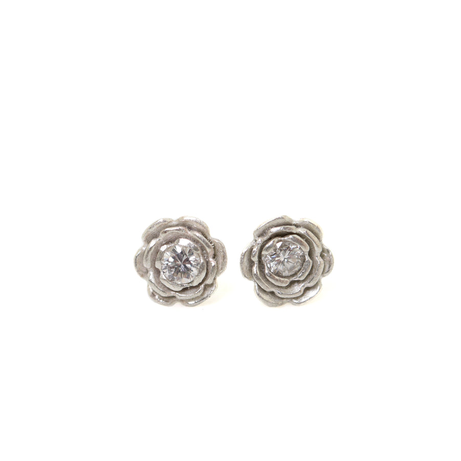 floral earrings studs made of silver, with a diamond set in the center of each flower.