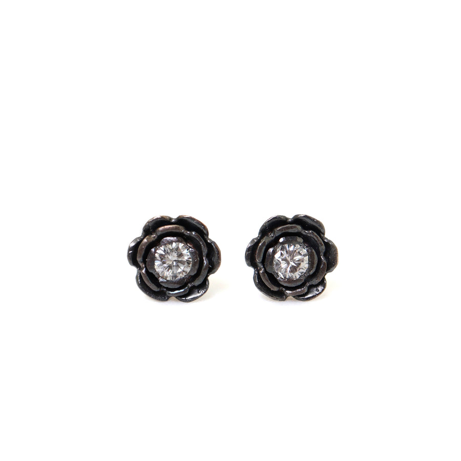 floral earrings studs made of oxidized silver, with a diamond set in the center of each flower.