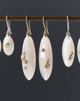 three pairs of mother of pearl drop earrings in sizes small, medium, and large, with either silver or gold barnacles