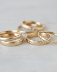 Ovoid gold bands with and without diamonds by Hannah Blount