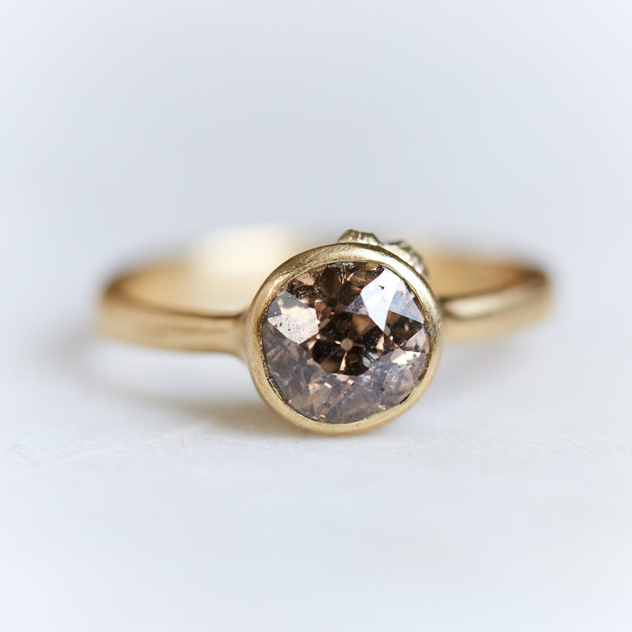 A 1.38ct diamond ring. The diamond has a chestnut hue and is set in 18k gold with an 18k gold band. The setting is encrusted with 14k gold barnacles. The ring is viewed from the front and is on a white background. 