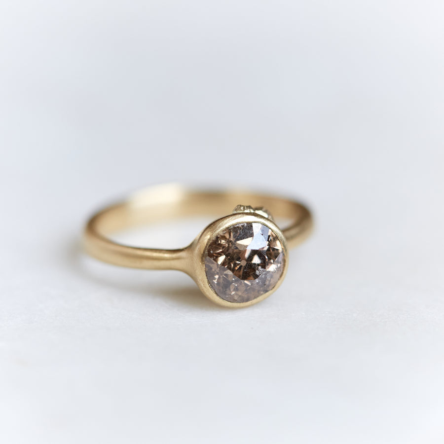 A 1.38ct diamond ring. The diamond has a chestnut hue and is set in 18k gold with an 18k gold band. The setting is encrusted with 14k gold barnacles. The ring is viewed off center and is set on a white background.