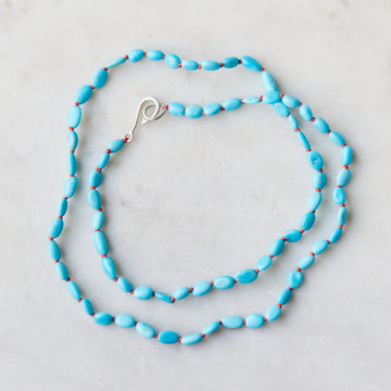 22in turquoise necklace on coral silk with silver clasp.