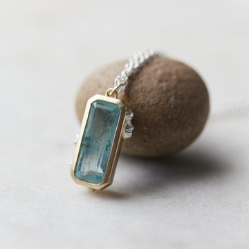 aquamarine rectangle set in yellow gold with silver barnacles, on a silver chain. Necklace.