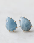 teardrop aquamarine faceted stones set in earring studs with gold prongs