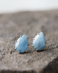 teardrop aquamarine faceted stones set in earring studs with gold prongs