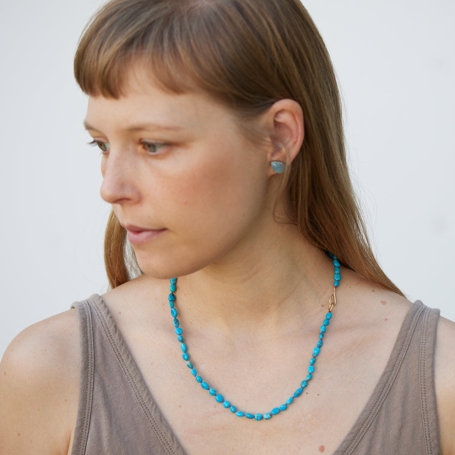 teardrop aquamarine faceted stones set in earring studs with gold prongs