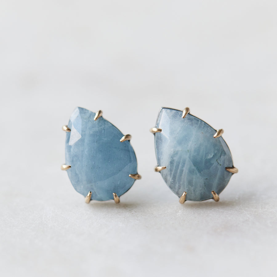 teardrop aquamarine faceted stones set in earring studs with gold prongs