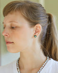 green garnet studs with silver barnacles on person