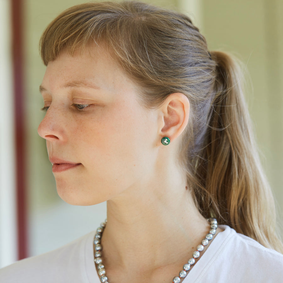 green garnet studs with silver barnacles on person