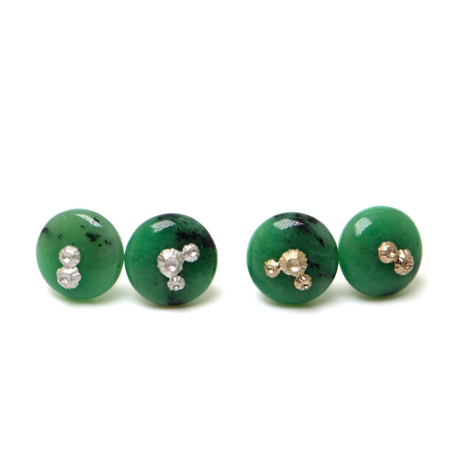 two pairs of green garnet earring studs, the left pair has silver barnacles and the right pair has gold barnacles.