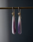 purple and white mottled quahog shell teardrops hang beneath gold ear wires with gold roses