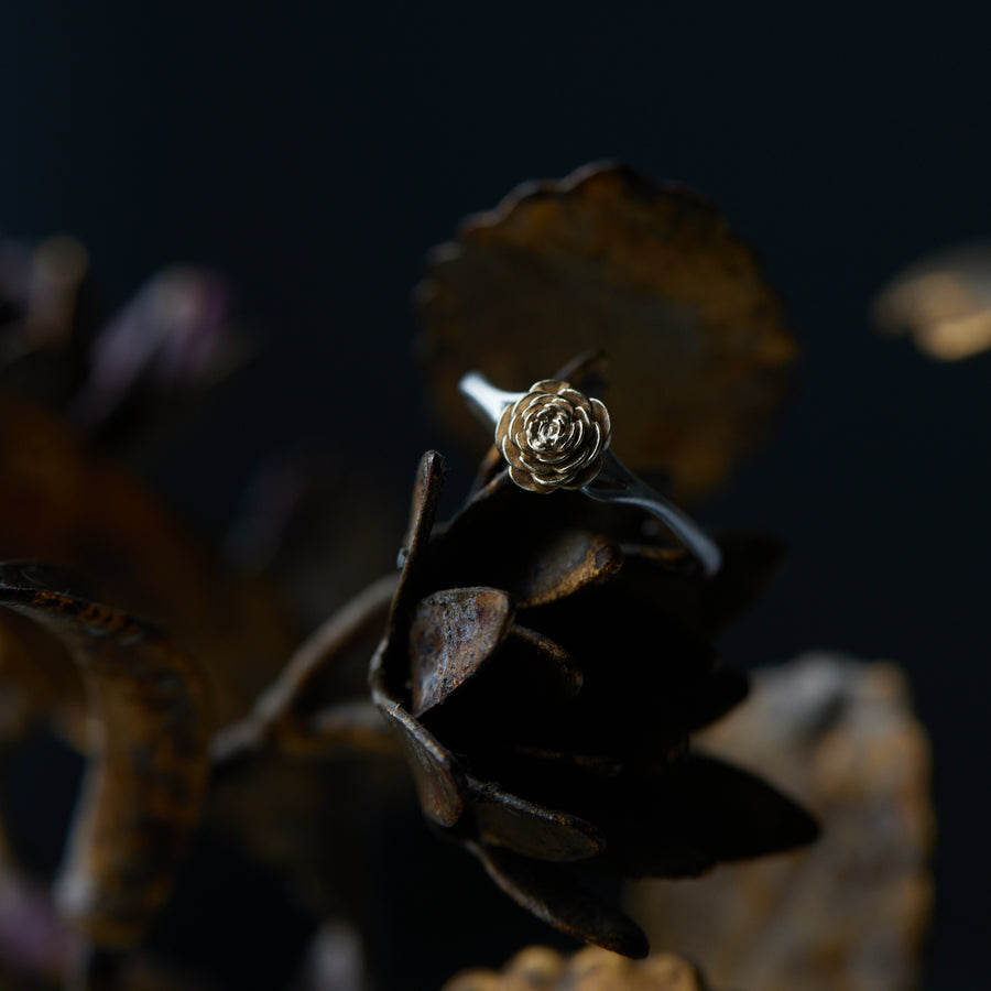 large rose garden ring, silver band with gold rose, sitting on metal flowers