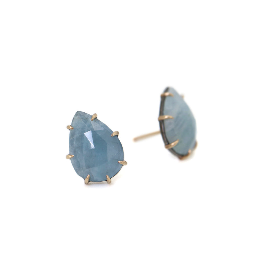 teardrop aquamarine faceted stones set in earring studs with gold prongs