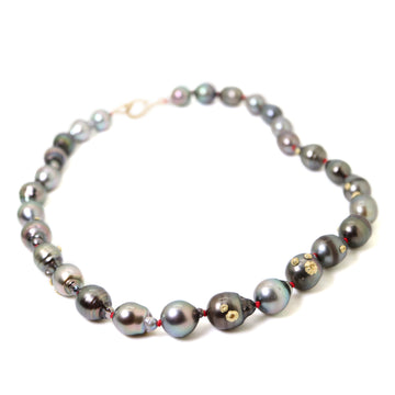 necklace made from chunky grey and black tahitian pearls, strung on red silk with gold barnacles and fish hook clasp