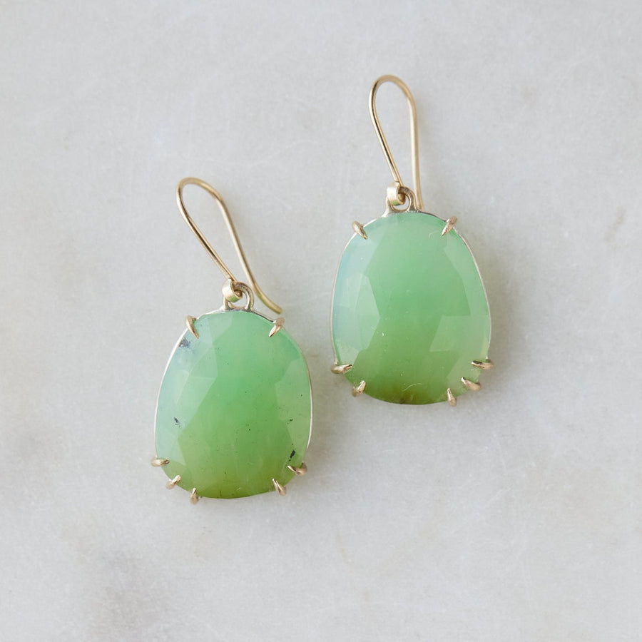 lush green chrysoprase faceted gemstones hang beneath gold ear wires and are set within gold prongs