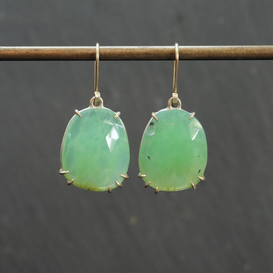 lush green chrysoprase faceted gemstones hang beneath gold ear wires and are set within gold prongs. 