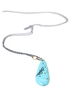 kingman turquoise teardrop bead with ink scrimshaw of codfish and little fishes. Necklace with gold and oxidized silver.