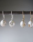 two pairs of white pearl drop earrings with barnacles. One pair on the left has silver barnacles, the pair on the right has gold barnacles.