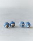 two pairs of blue common opal earring studs, left pair with silver barnacles and the right pair has gold barnacles.