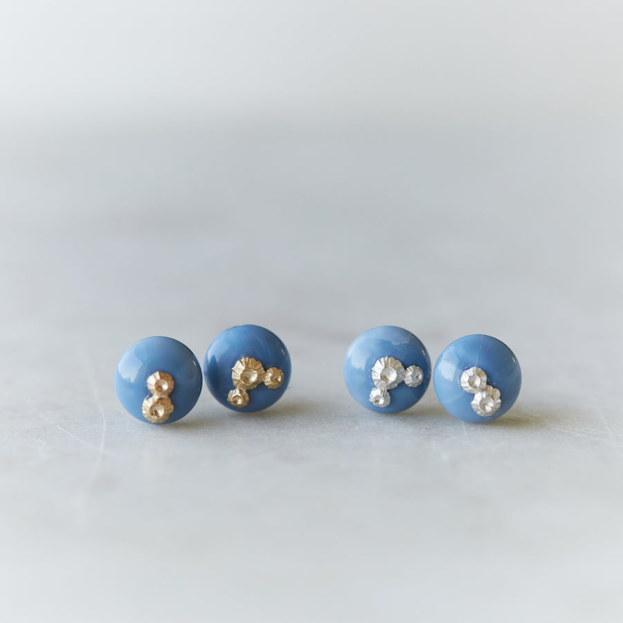 two pairs of blue common opal earring studs, left pair with silver barnacles and the right pair has gold barnacles.