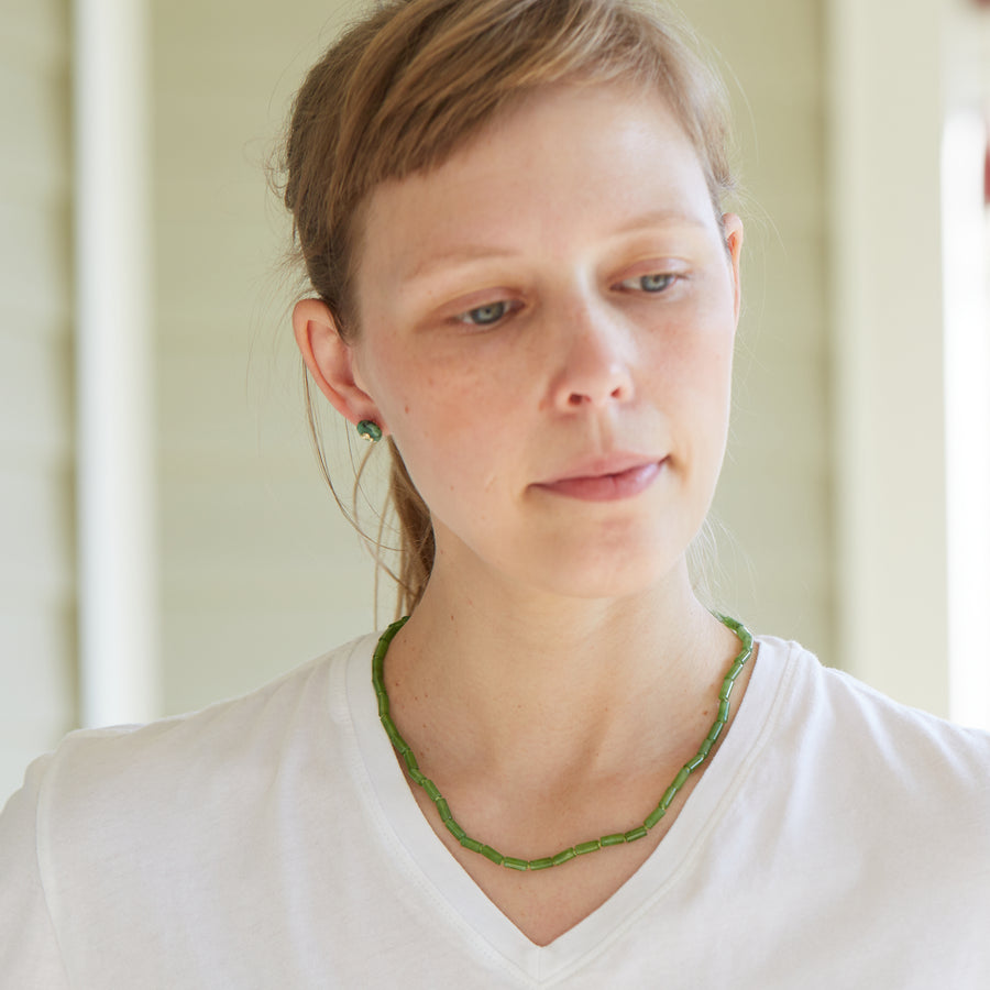 Green jade strand necklace with gold clasp by Hannah Blount on person