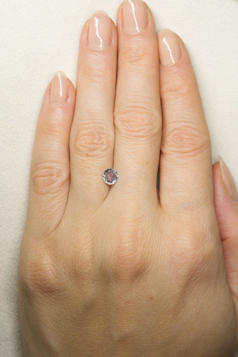 1.02ct Pale blue montana sapphire on hand for scale